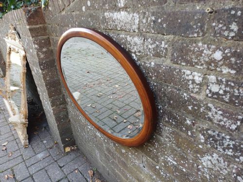 fig 2. An oval mahogany framed wall mirror featuring a bevelled glass edge and subtle fine string inlay detail around the perimeter.