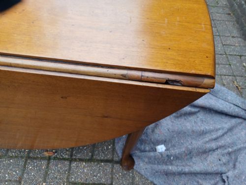 fig 6. An antique mahogany drop-leaf dining table with one hinged leaf raised, standing on tapered legs with pad feet.