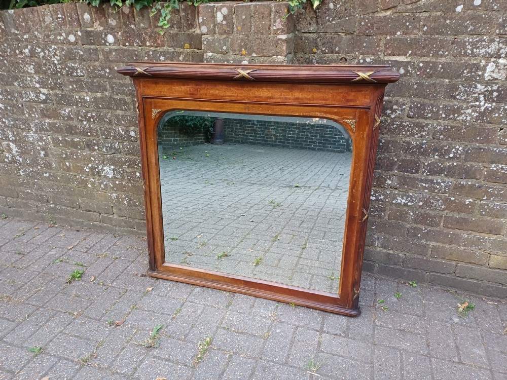 A large Edwardian wooden overmantel mirror featuring marquetry inlay, a reeded frame with gilded cross-ribbon details, and an arched upper glass line. View III