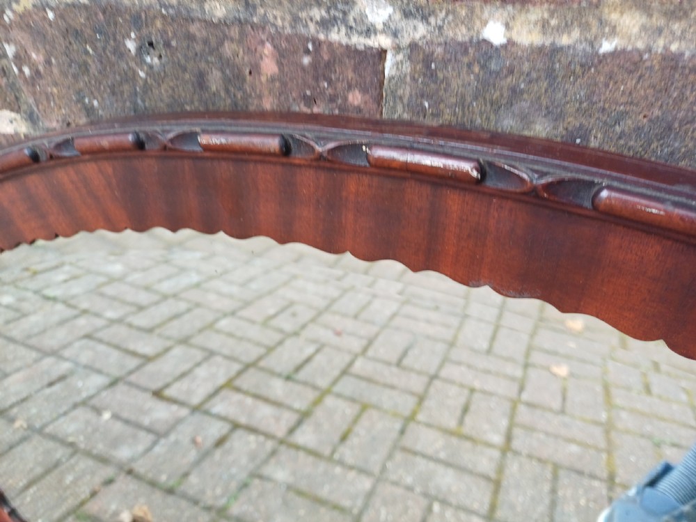 A large horizontal oval wall mirror featuring a carved mahogany wooden frame and a bevelled glass edge. View IV
