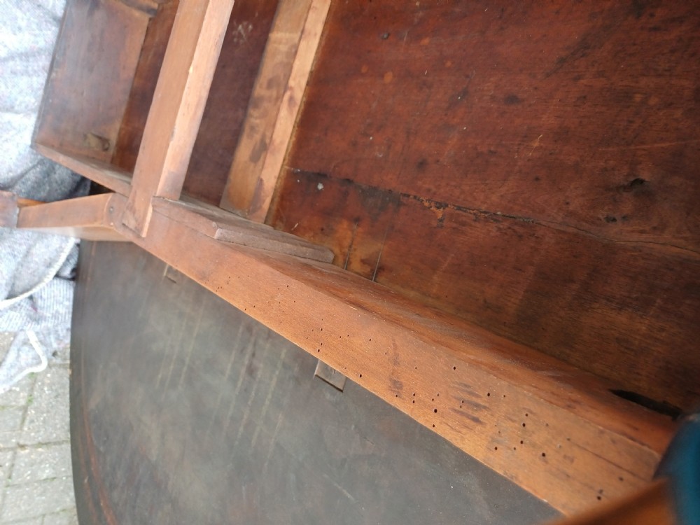 An antique mahogany drop-leaf dining table with one hinged leaf raised, standing on tapered legs with pad feet. View V