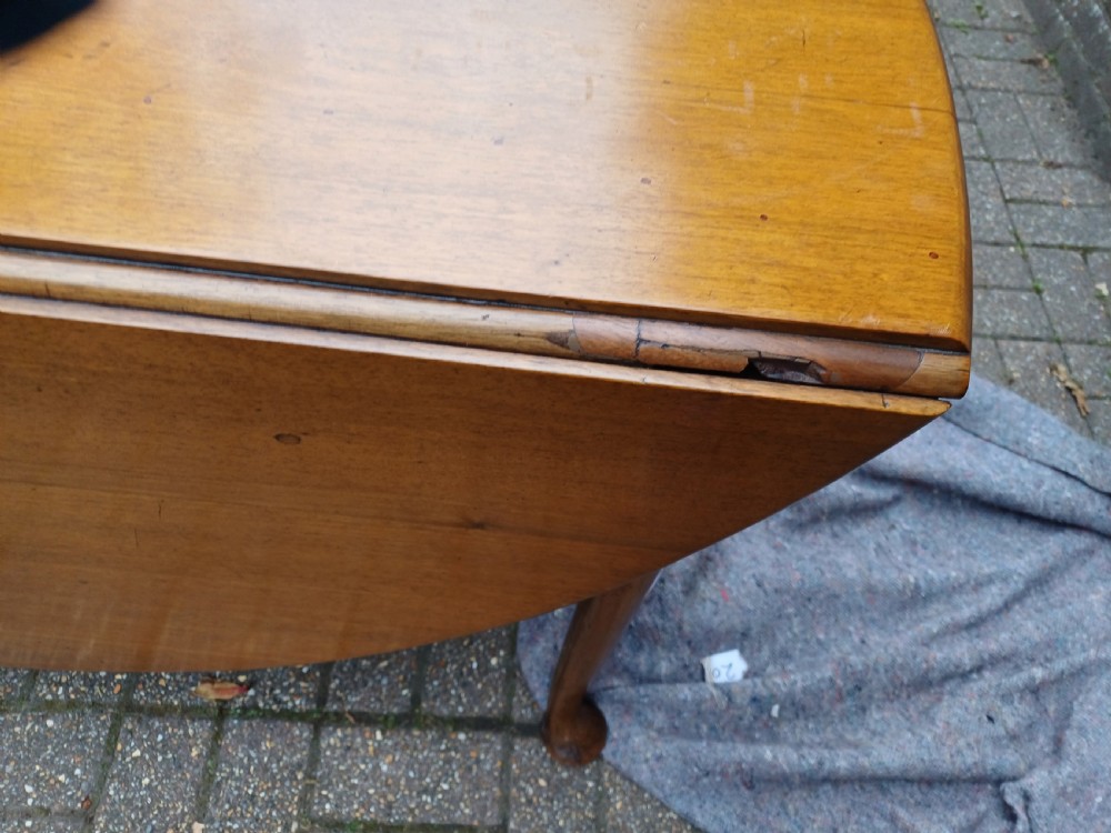 An antique mahogany drop-leaf dining table with one hinged leaf raised, standing on tapered legs with pad feet. View VII