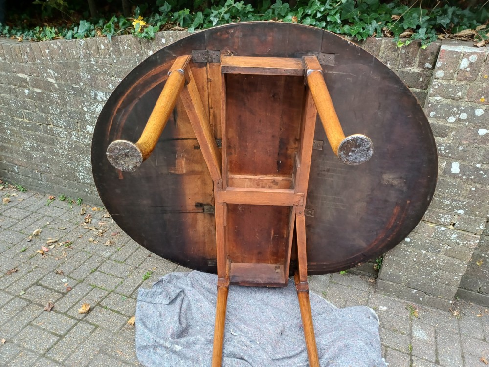 An antique mahogany drop-leaf dining table with one hinged leaf raised, standing on tapered legs with pad feet. View XI