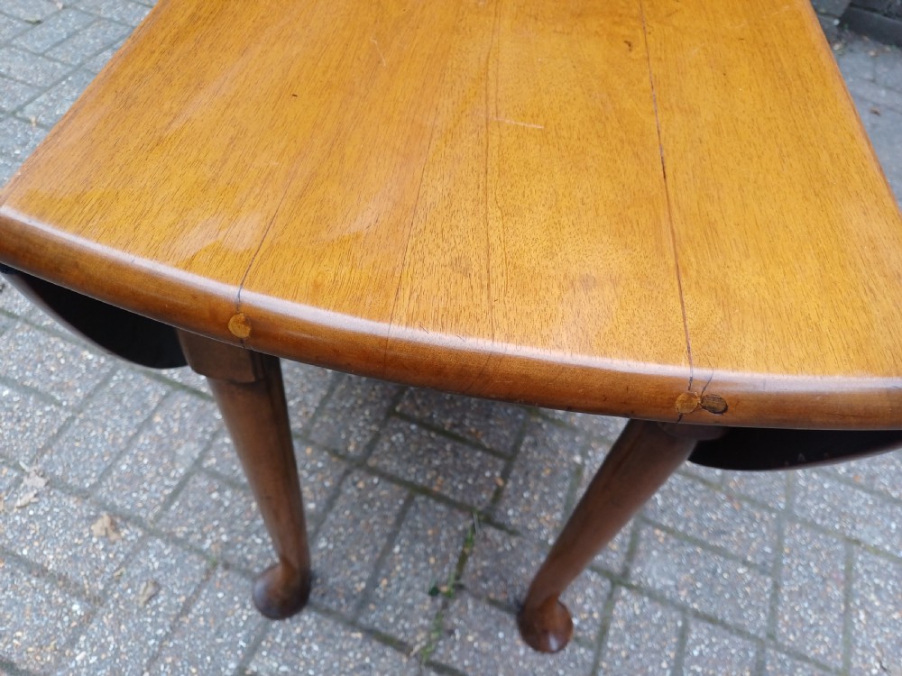 An antique mahogany drop-leaf dining table with one hinged leaf raised, standing on tapered legs with pad feet. View XVI