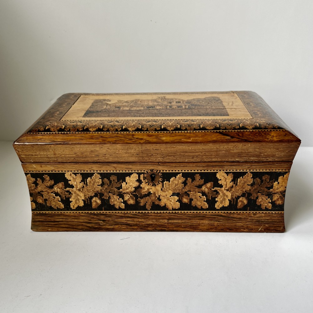 A rectangular Victorian Tunbridge ware wooden box featuring flared concave sides, a hinged lid decorated with an inlaid landscape, and leaf mosaic borders. View II