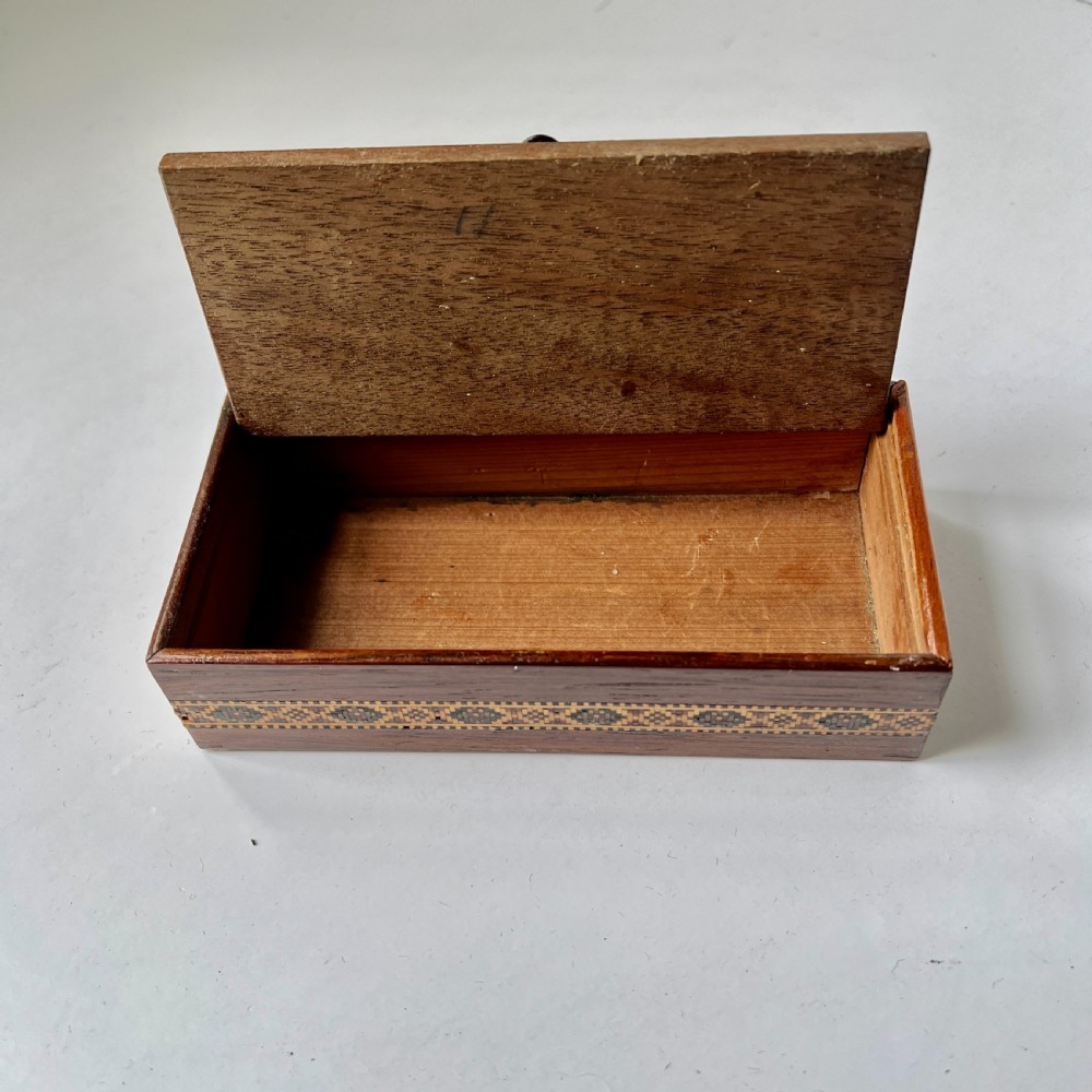 A small rectangular wooden trinket box featuring a geometric tumbling block mosaic lid and an inlaid patterned border. View IV