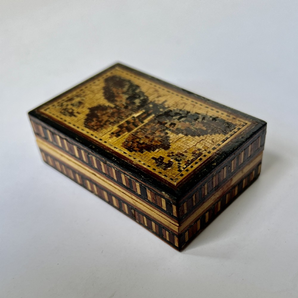 A small rectangular wooden trinket box featuring a detailed micro-mosaic wood inlay image of a butterfly on the lid and geometric mosaic banding along the sides.