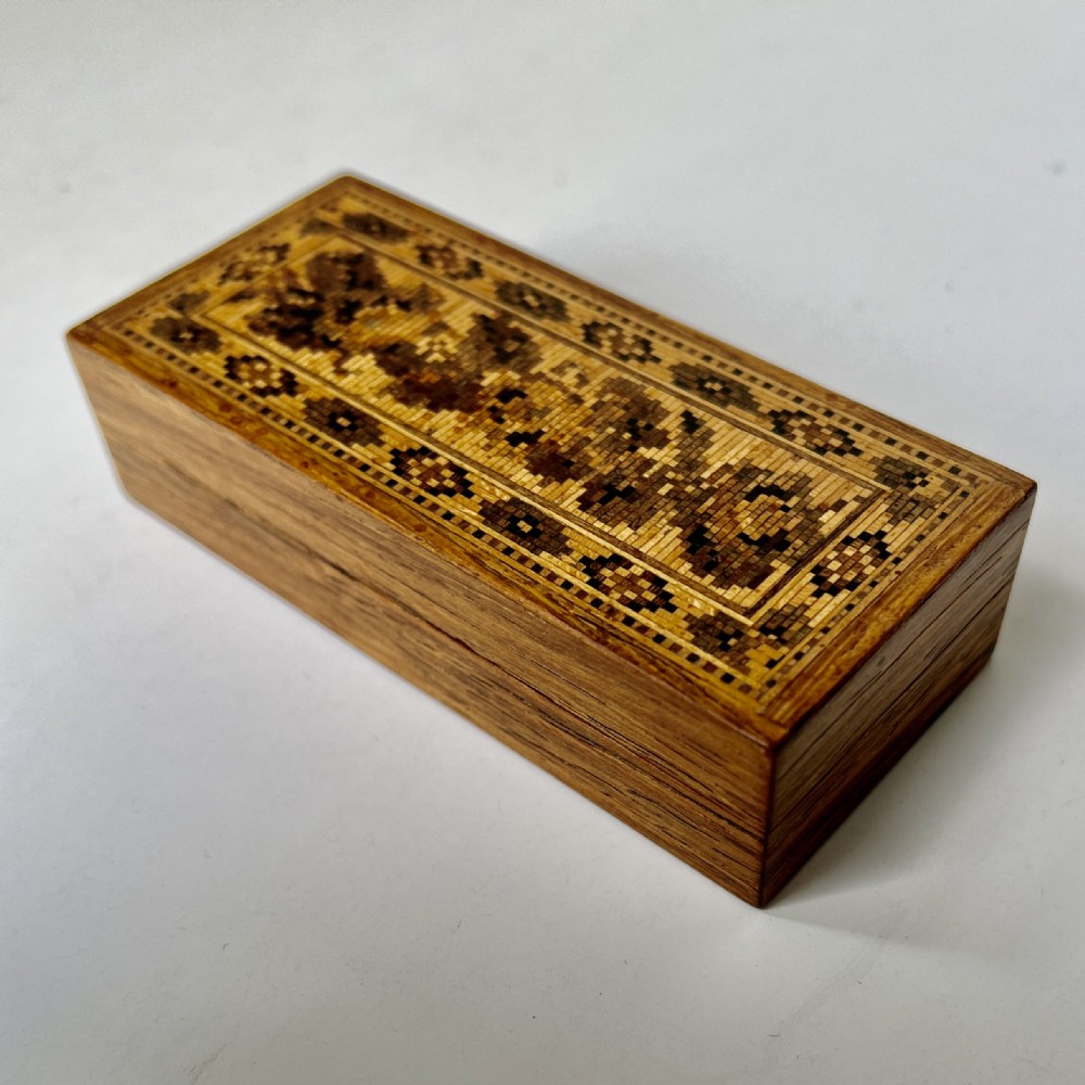 A small rectangular Victorian rosewood trinket box featuring a flat lid decorated with detailed geometric wooden mosaic marquetry.