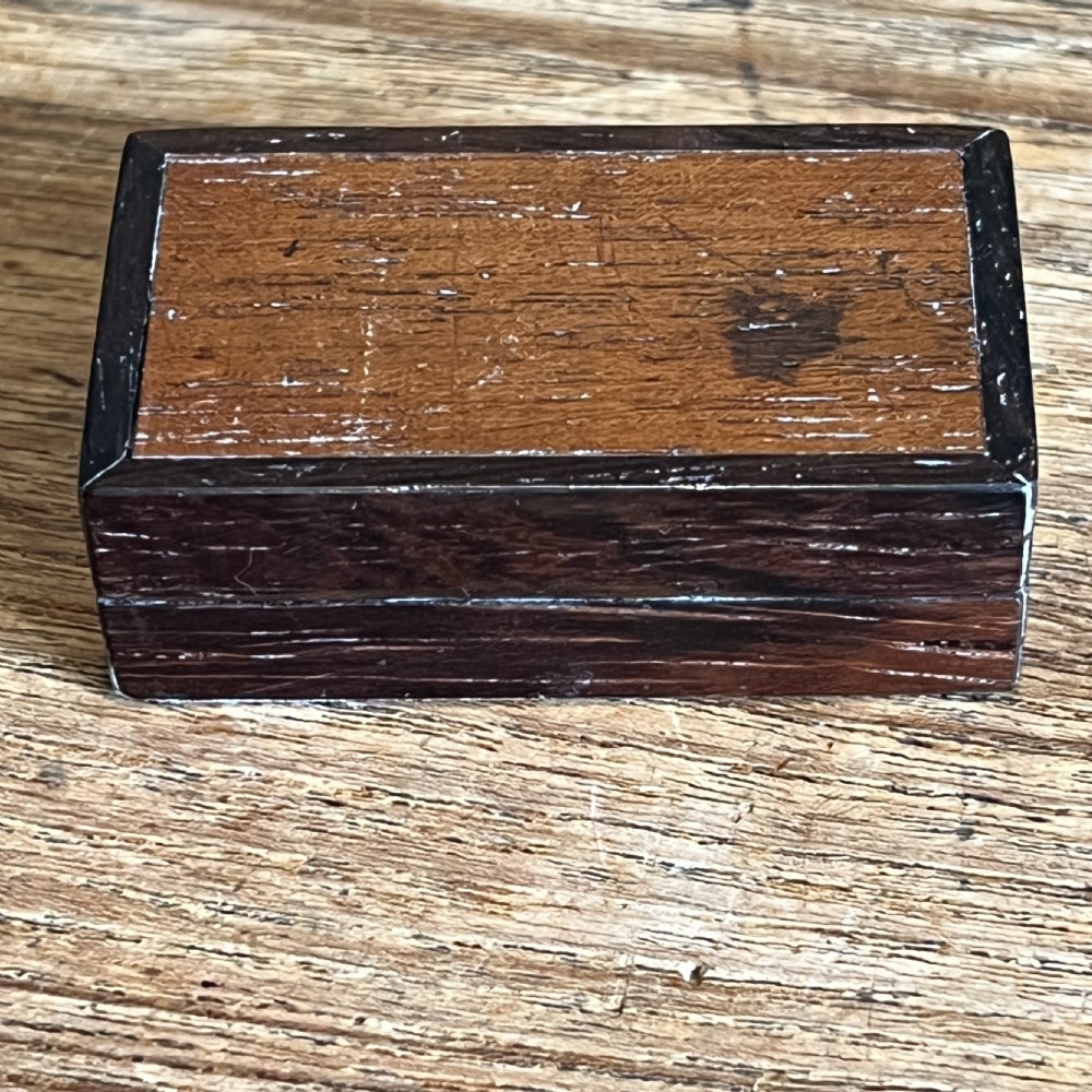 A small rectangular Victorian wooden pin box featuring geometric parquetry inlay in contrasting light and dark woods across the lid. View V