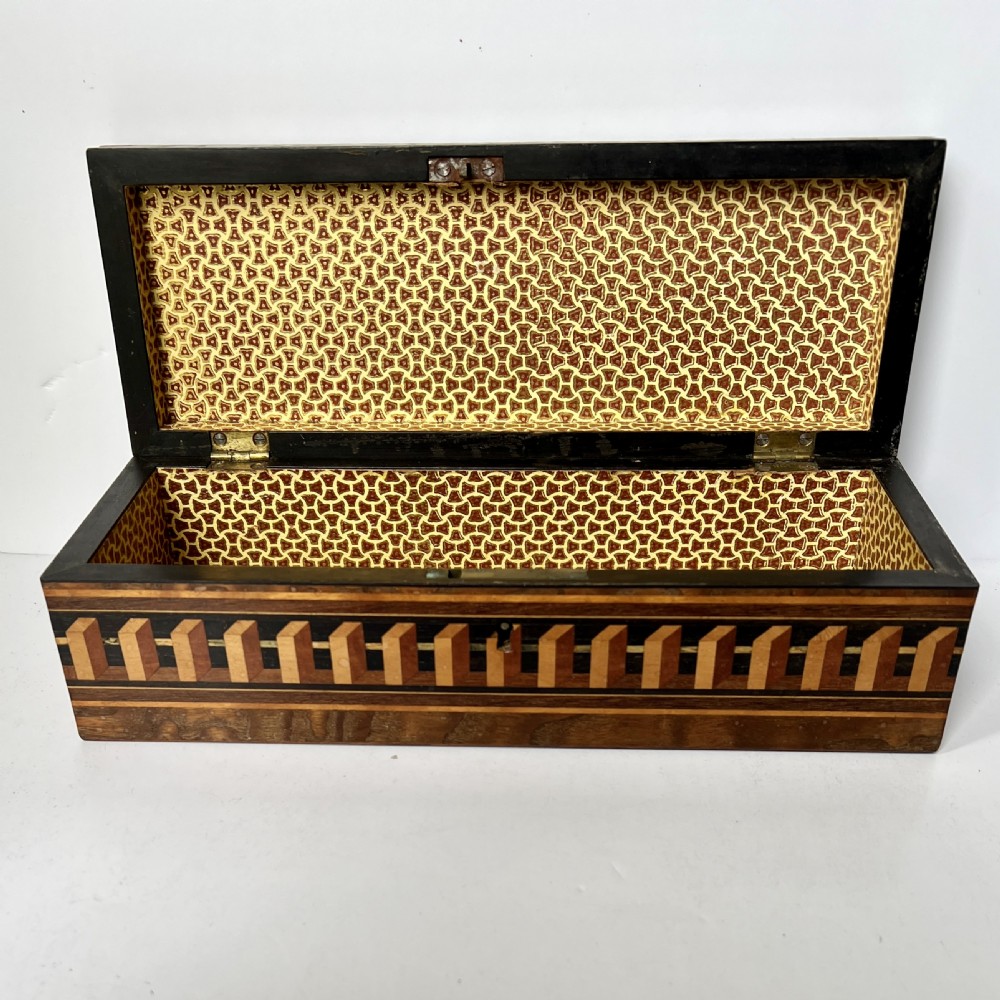 A rectangular Victorian Tunbridge ware wooden glove box with a floral mosaic top panel and a geometric inlaid border. View IV