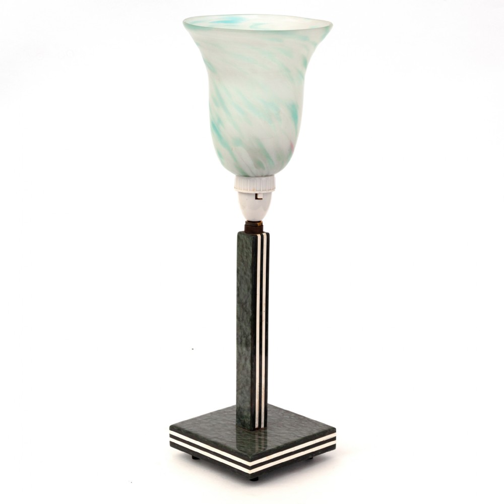 An Art Deco table lamp featuring a dark green marbled square base with white striped accents, a matching vertical stem, and a flared glass shade with blue-green swirls.