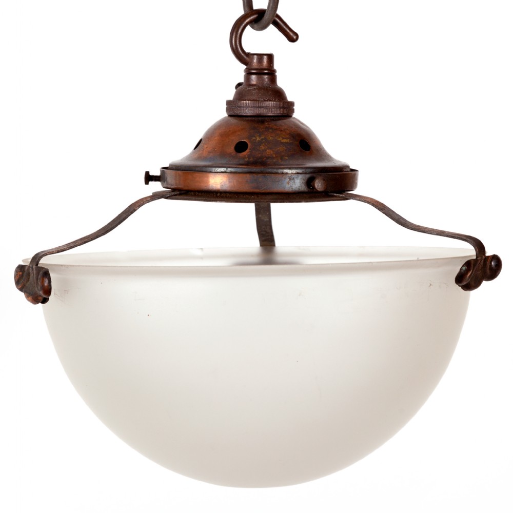 An Art Deco hemispherical frosted glass pendant shade suspended from a patinated copper gallery with metal support arms and a hanging hook.