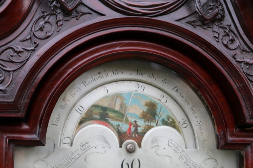 An 18th-century Chippendale flame mahogany longcase clock featuring a swan-neck pediment, reeded columns, and a painted arch dial face. View IX