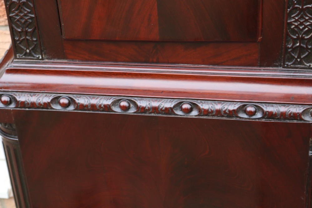 An 18th-century Chippendale flame mahogany longcase clock featuring a swan-neck pediment, reeded columns, and a painted arch dial face. View XI