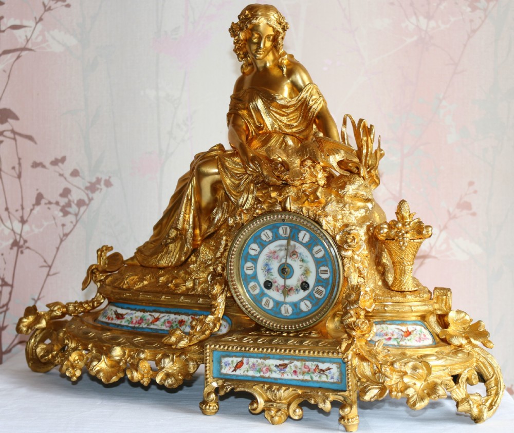 An ornate 19th-century French gilt bronze ormolu mantel clock topped with a classic draped female figure, featuring turquoise porcelain panels painted with flowers and birds. View III