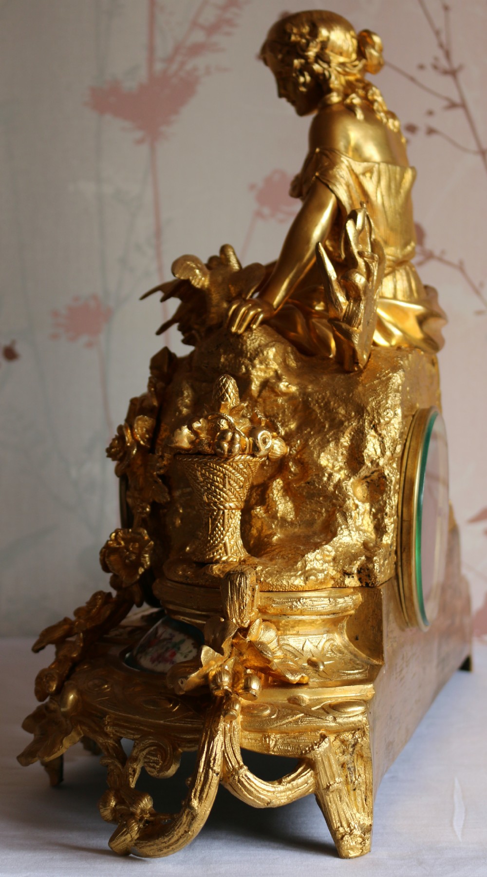 An ornate 19th-century French gilt bronze ormolu mantel clock topped with a classic draped female figure, featuring turquoise porcelain panels painted with flowers and birds. View V