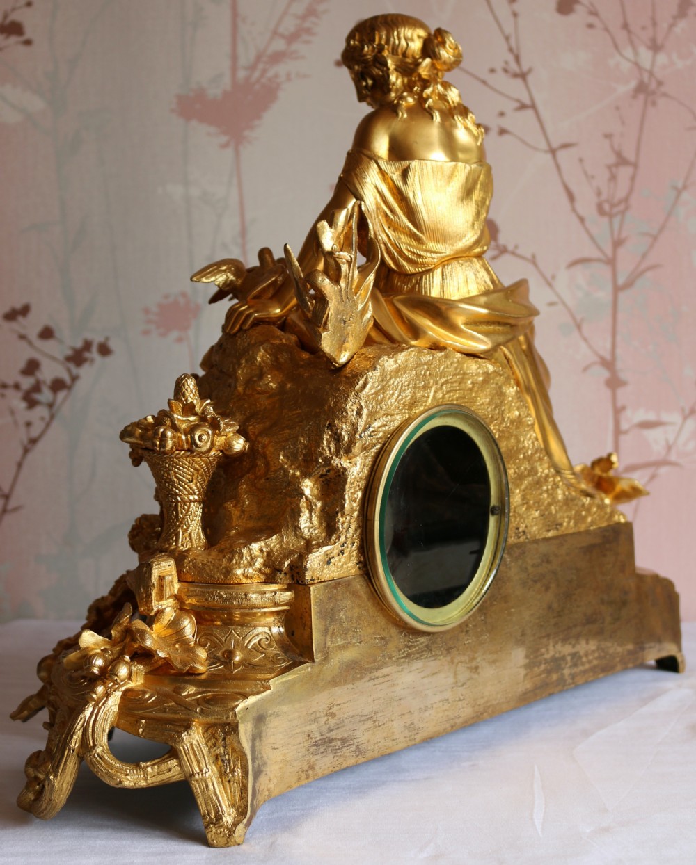An ornate 19th-century French gilt bronze ormolu mantel clock topped with a classic draped female figure, featuring turquoise porcelain panels painted with flowers and birds. View VI