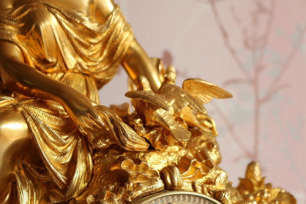 An ornate 19th-century French gilt bronze ormolu mantel clock topped with a classic draped female figure, featuring turquoise porcelain panels painted with flowers and birds. View XII