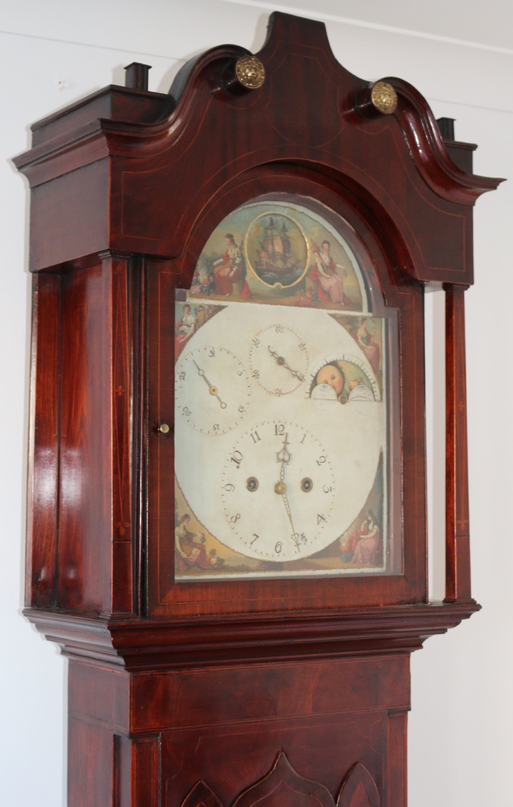 A Georgian mahogany longcase clock featuring a swan-neck pediment, a hand-painted dial with auxiliary subdials, and a rocking ship automaton in the arch. View V