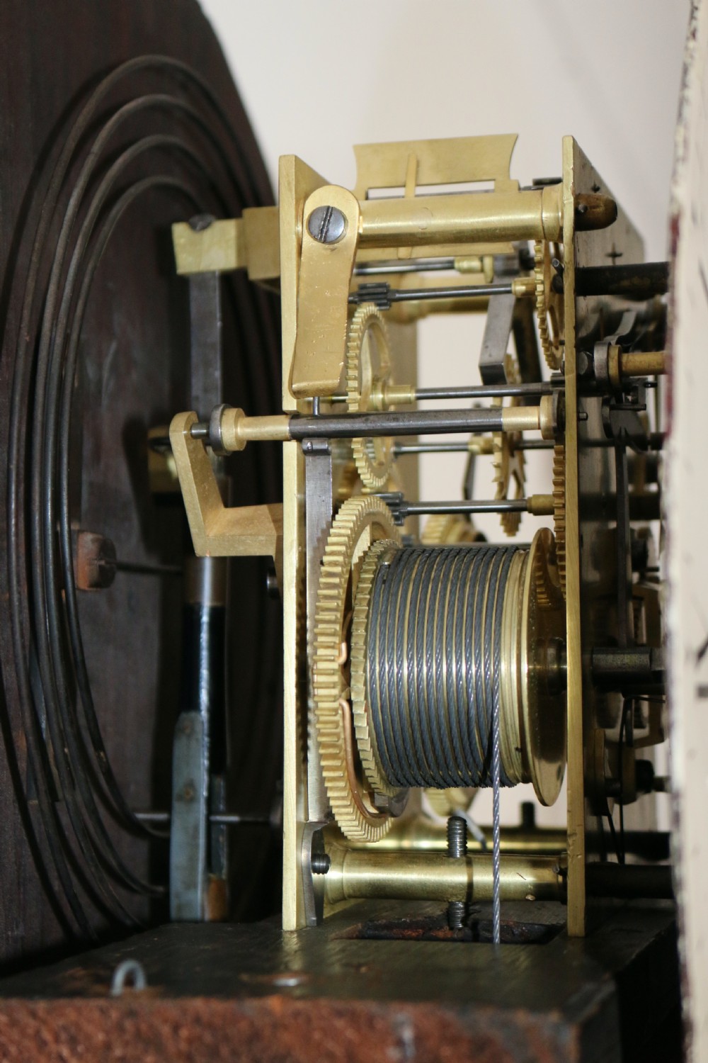 A tall flame mahogany Scottish regulator longcase clock featuring a circular white painted dial, carved top scrollwork, and a glazed door showing brass weights. View VII