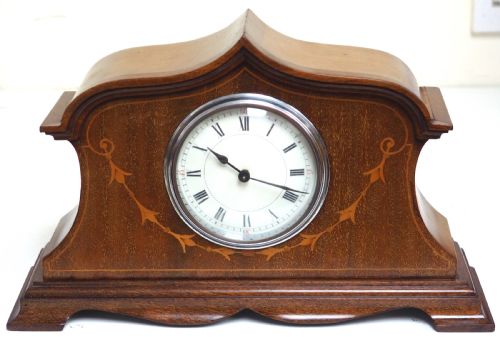 fig 1. An Edwardian mahogany mantel clock featuring a stepped tulip-top case, floral marquetry inlay, and a white circular dial with Roman numerals.