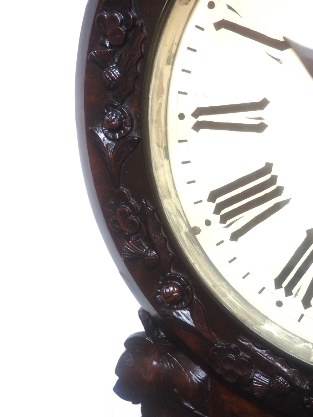 An antique Victorian carved dark mahogany wall clock featuring an off-white dial with Roman numerals marked Berry Cardiff, framed by thistle and vine carvings. View VIII