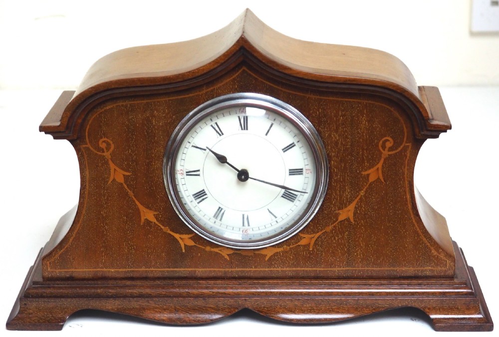 An Edwardian mahogany mantel clock featuring a stepped tulip-top case, floral marquetry inlay, and a white circular dial with Roman numerals. View II