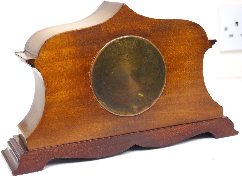 An Edwardian mahogany mantel clock featuring a stepped tulip-top case, floral marquetry inlay, and a white circular dial with Roman numerals. View VIII