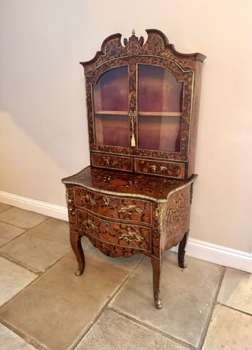 fig 1. An 18th-century Dutch walnut display cabinet featuring intricate floral marquetry inlay, glazed upper doors, and a bombe chest base on cabriole legs.