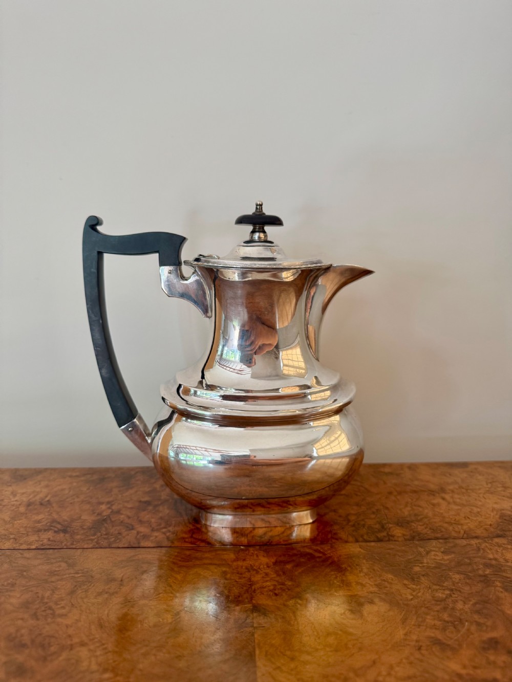 A four-piece Edwardian silver tea set comprising a teapot, coffee pot, cream jug, and sugar bowl with black wooden handles. View III
