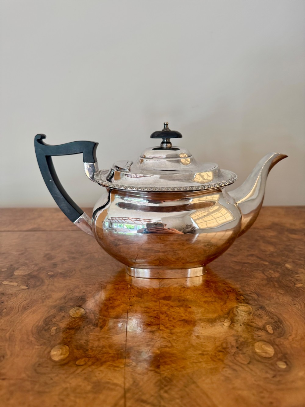 A four-piece Edwardian silver tea set comprising a teapot, coffee pot, cream jug, and sugar bowl with black wooden handles. View IV