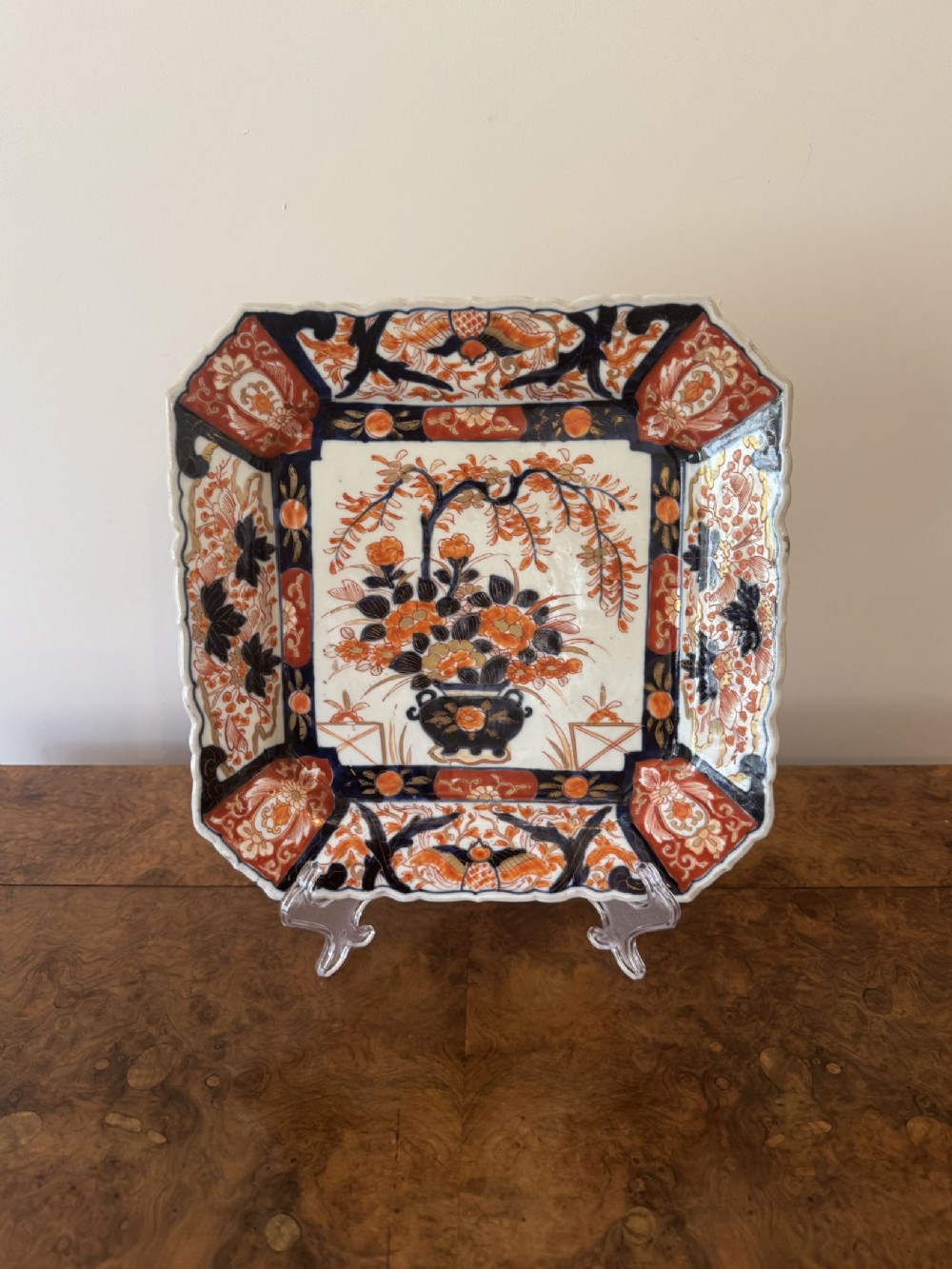 A square antique Japanese Imari porcelain plate featuring a scalloped rim and hand-painted floral motifs in cobalt blue, iron-red, and gold accents.