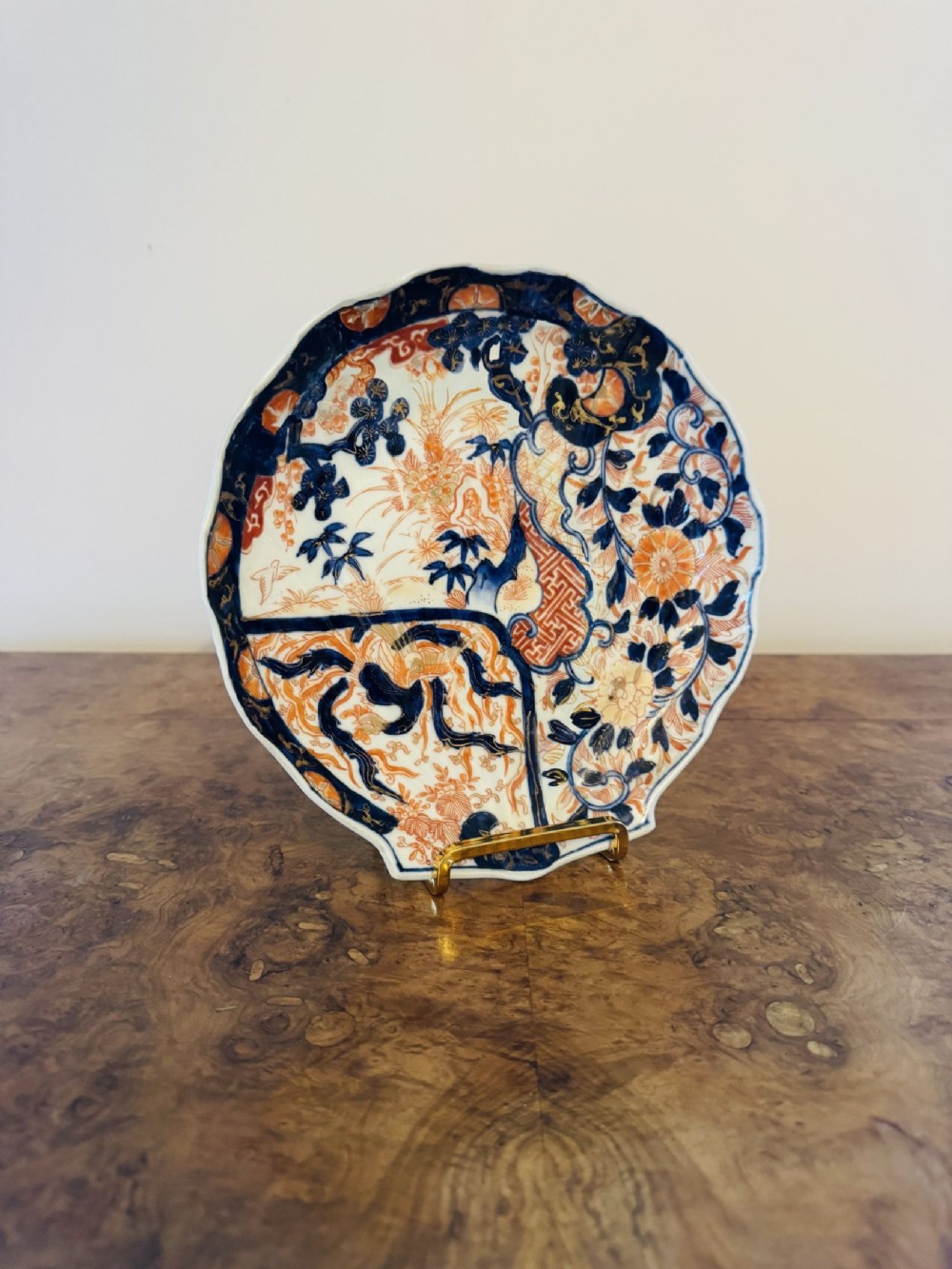 A Japanese Imari porcelain plate formed in a scalloped shell shape, decorated with cobalt blue underglaze and iron-red enamel floral motifs.