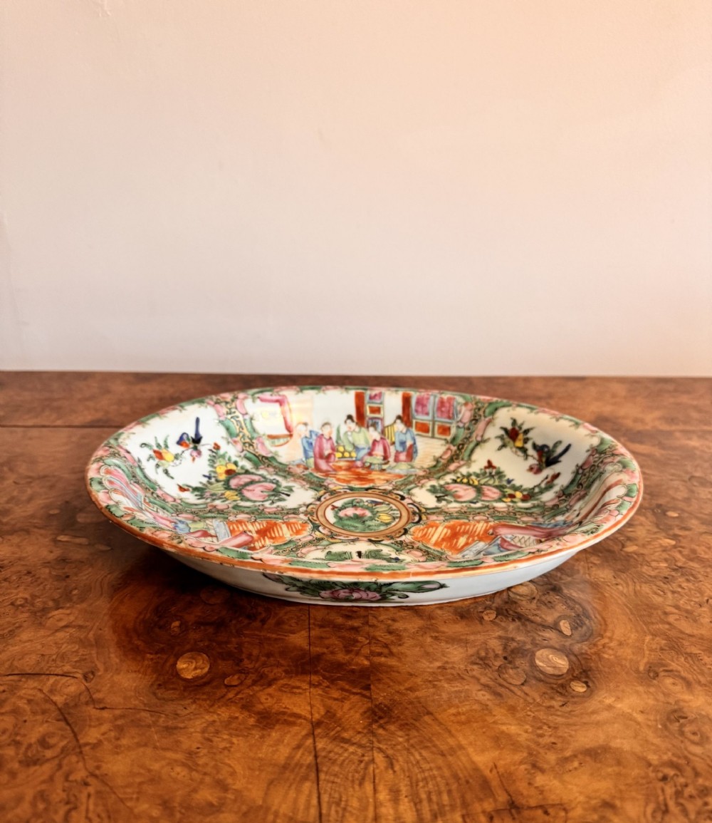 An oval 19th-century Chinese export porcelain dish painted with Rose Medallion panels featuring figures, birds, and flowers in pink and green enamels. View III