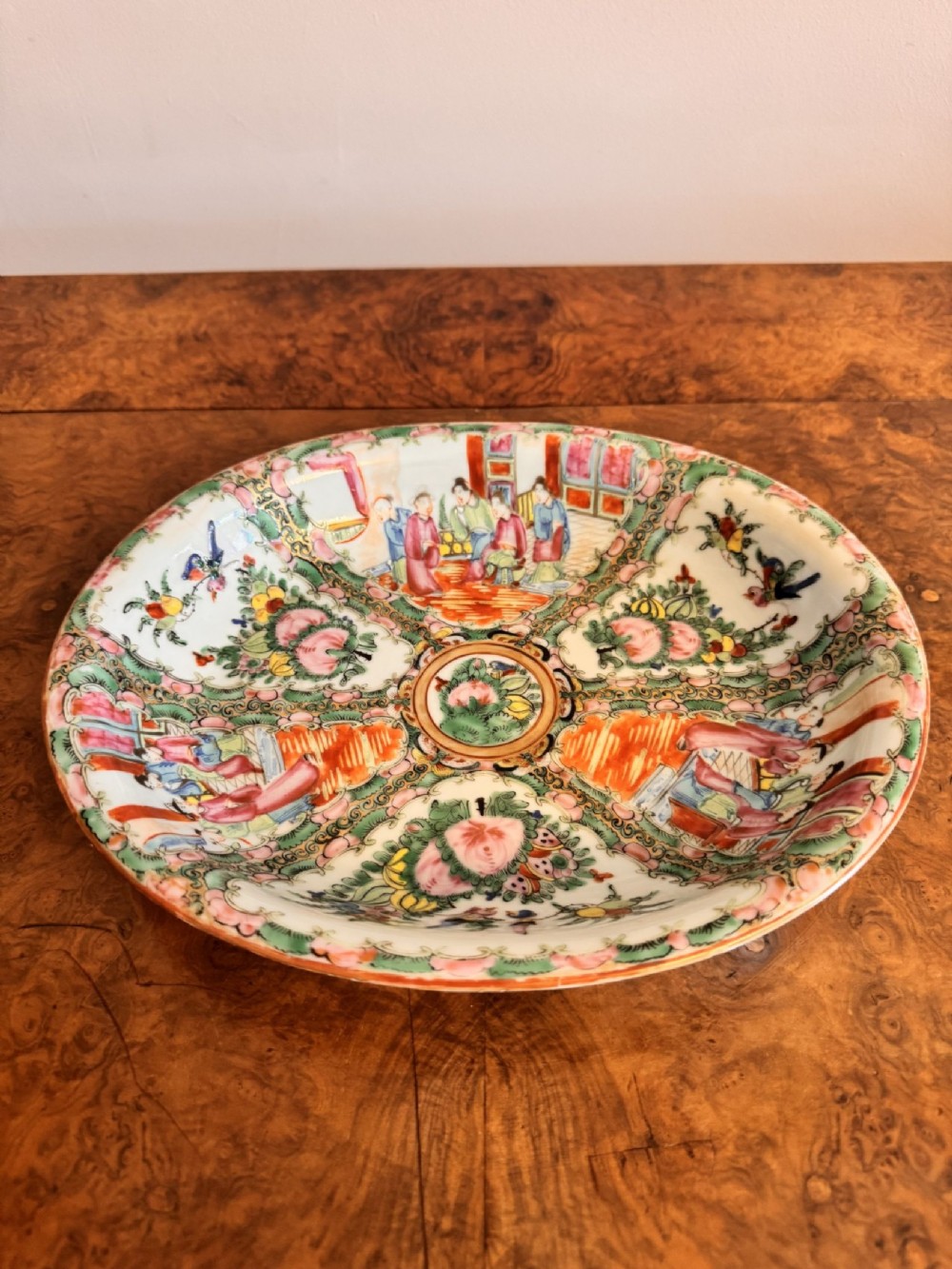 An oval 19th-century Chinese export porcelain dish painted with Rose Medallion panels featuring figures, birds, and flowers in pink and green enamels. View II