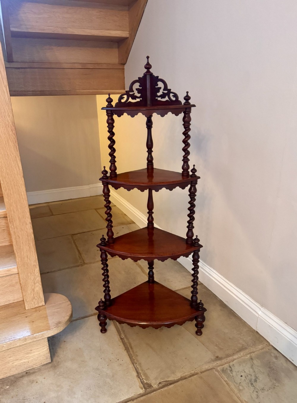 A four-tier Victorian mahogany corner whatnot featuring spiral barley twist supports, a carved pierced fretwork gallery, and scalloped shelf edges.