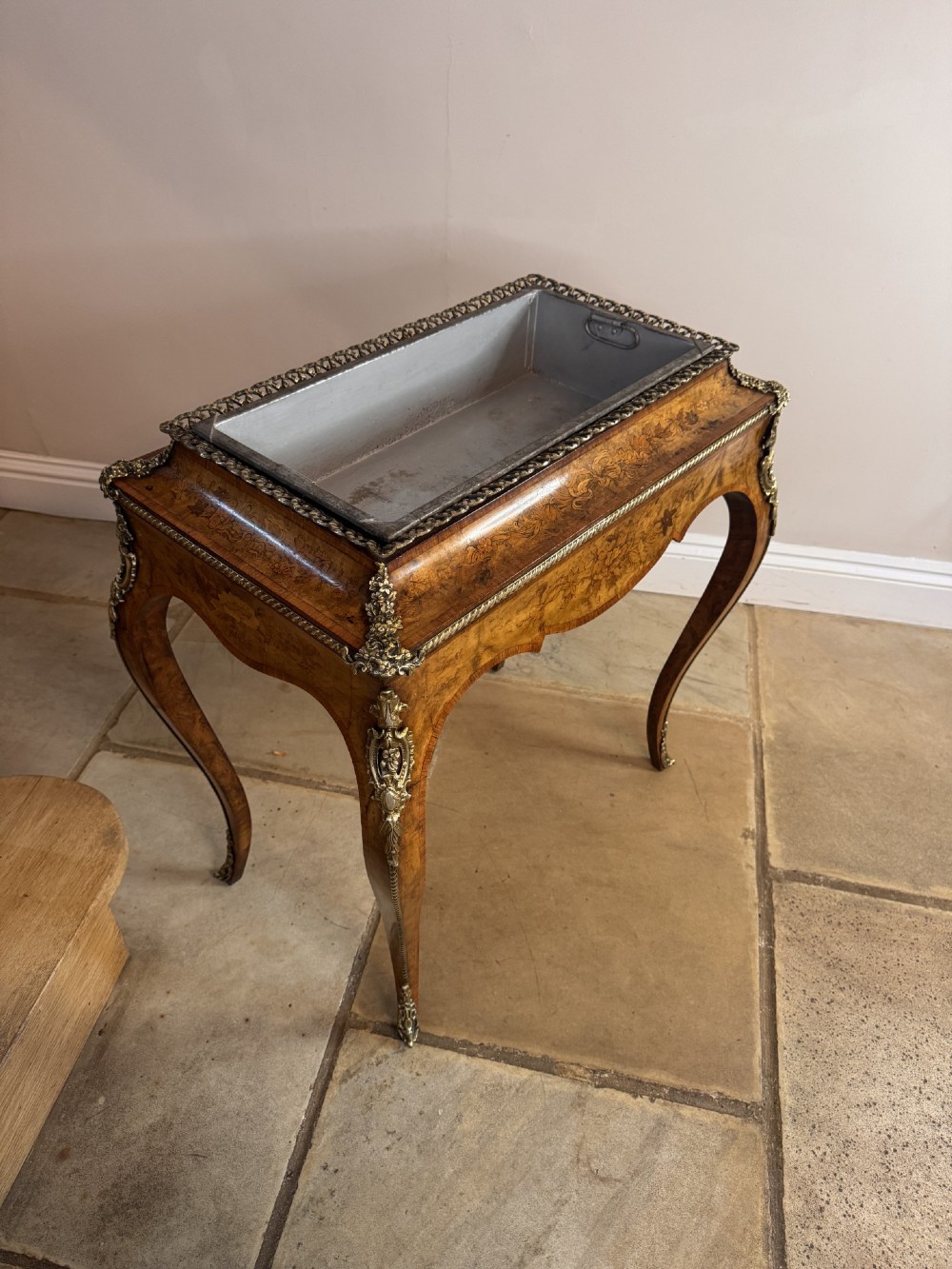 A Victorian walnut jardiniere table featuring intricate floral marquetry inlay, sweeping cabriole legs with decorative metal mounts, and a recessed metal liner. View II