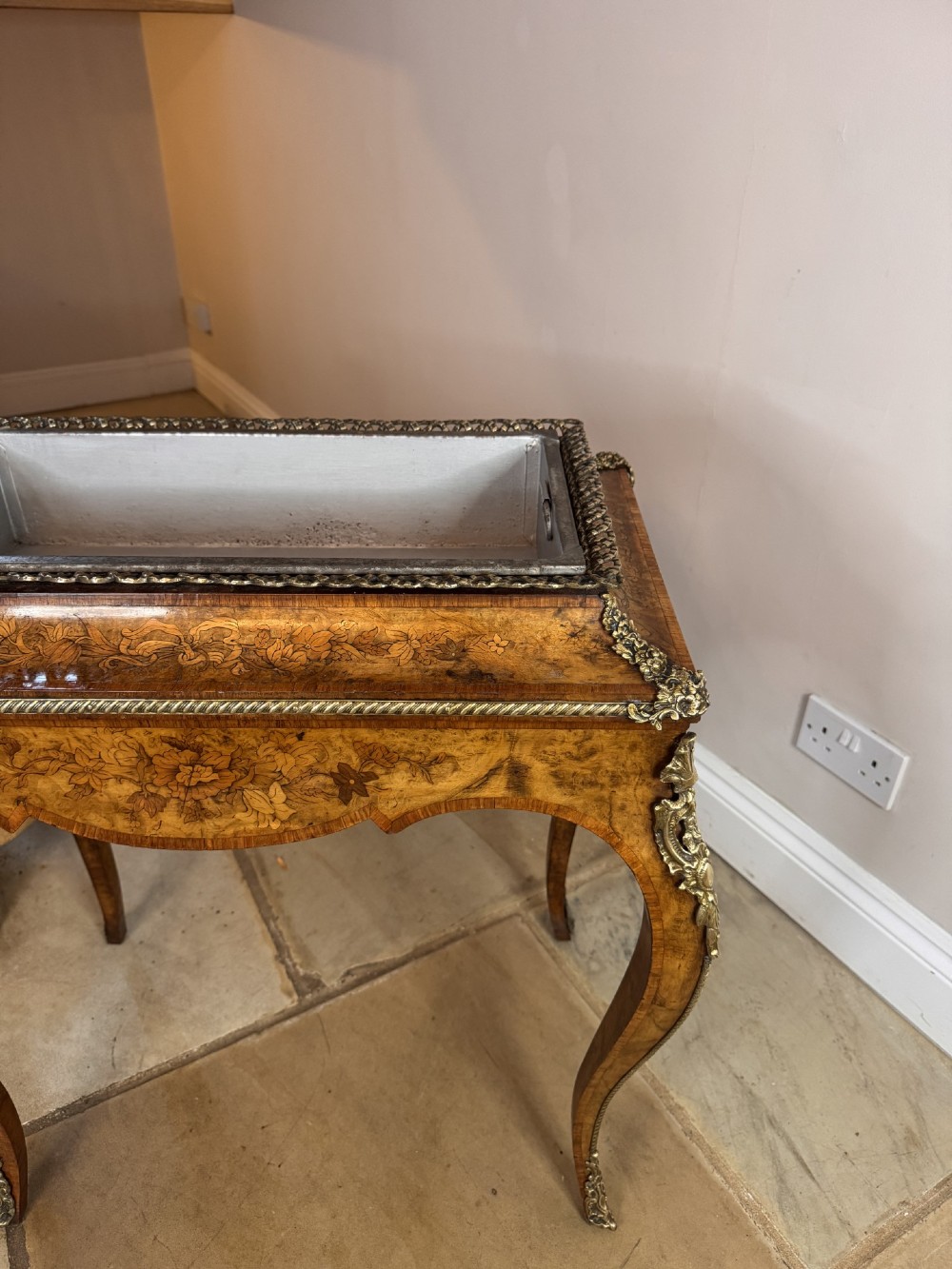 A Victorian walnut jardiniere table featuring intricate floral marquetry inlay, sweeping cabriole legs with decorative metal mounts, and a recessed metal liner. View III