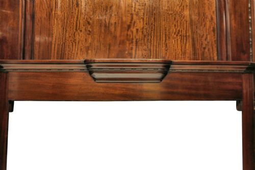 fig 1. A large dark polished mahogany chimneypiece featuring an integrated panelled overmantel and architectural stepped mouldings.