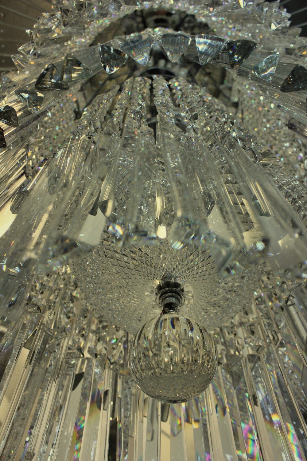 A monumental tiered Art Deco chandelier featuring a sunburst mirrored corona above cascading cylindrical layers of crystal prisms. View VIII