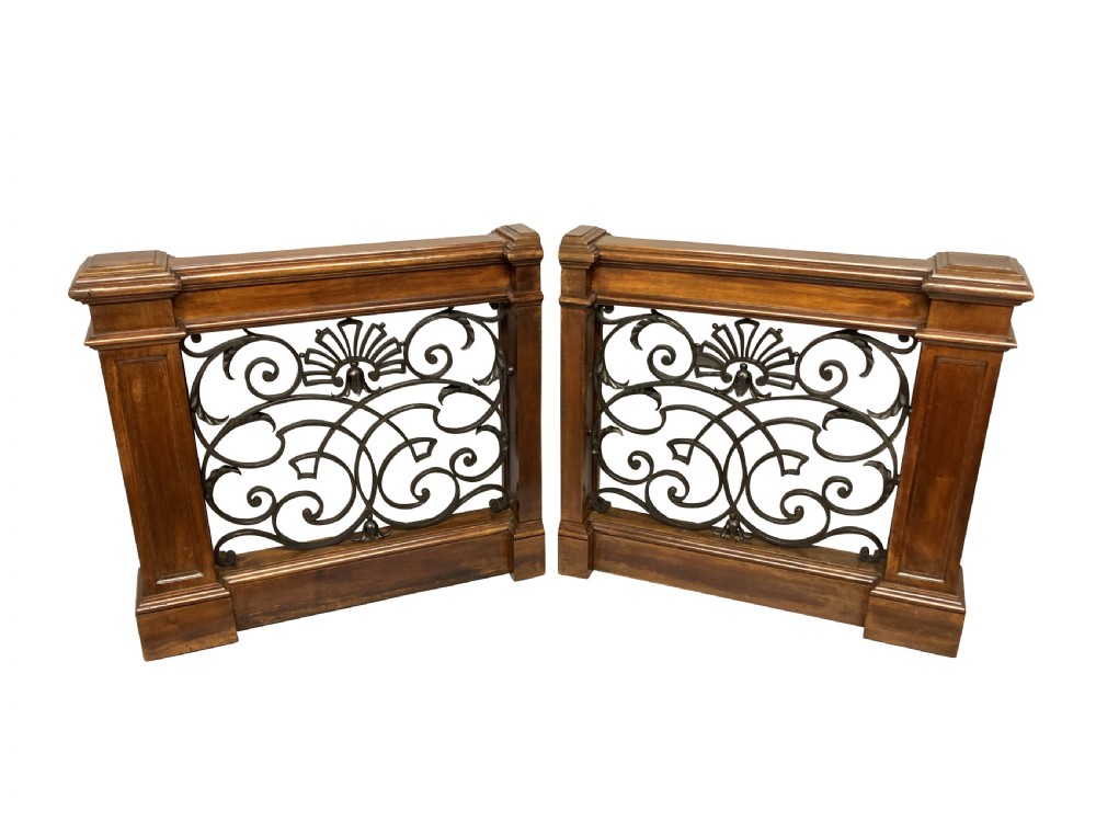A pair of wooden-framed architectural balustrades featuring central wrought iron panels with scrolled patterns and fan motifs. View II