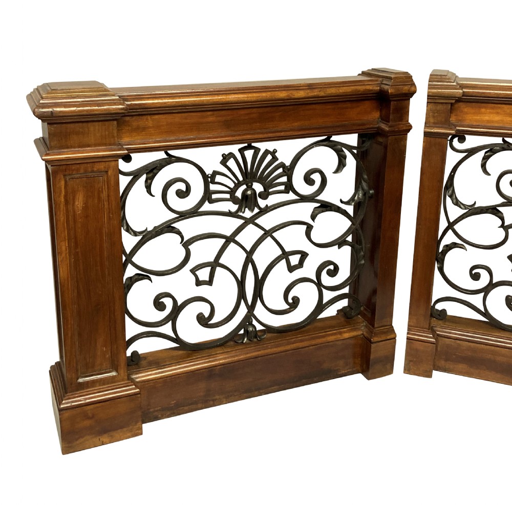 A pair of wooden-framed architectural balustrades featuring central wrought iron panels with scrolled patterns and fan motifs. View III