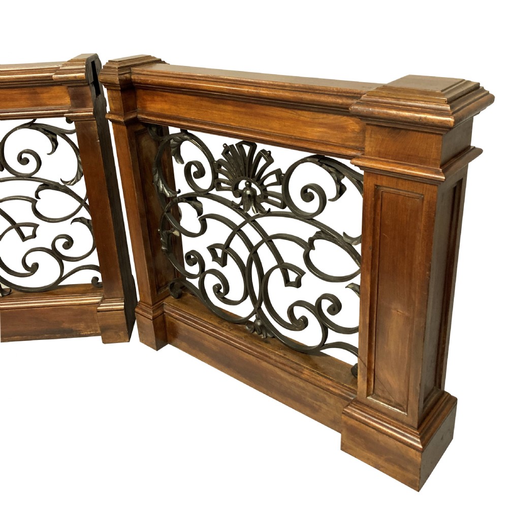 A pair of wooden-framed architectural balustrades featuring central wrought iron panels with scrolled patterns and fan motifs. View IV
