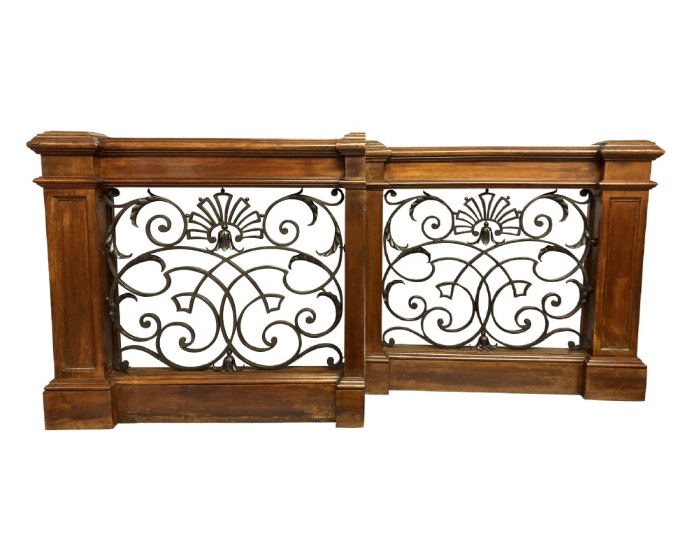 A pair of wooden-framed architectural balustrades featuring central wrought iron panels with scrolled patterns and fan motifs. View VI