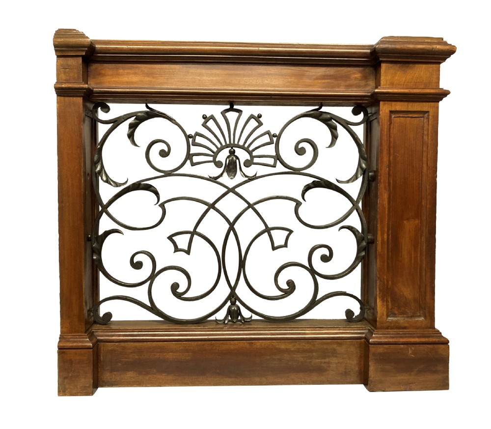 A pair of wooden-framed architectural balustrades featuring central wrought iron panels with scrolled patterns and fan motifs. View VII