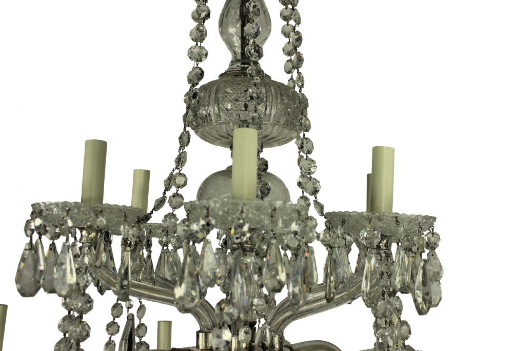 A multi-tiered nineteenth-century English cut glass chandelier featuring curved glass arms, faceted crystal drops, and glass candle sleeves. View II