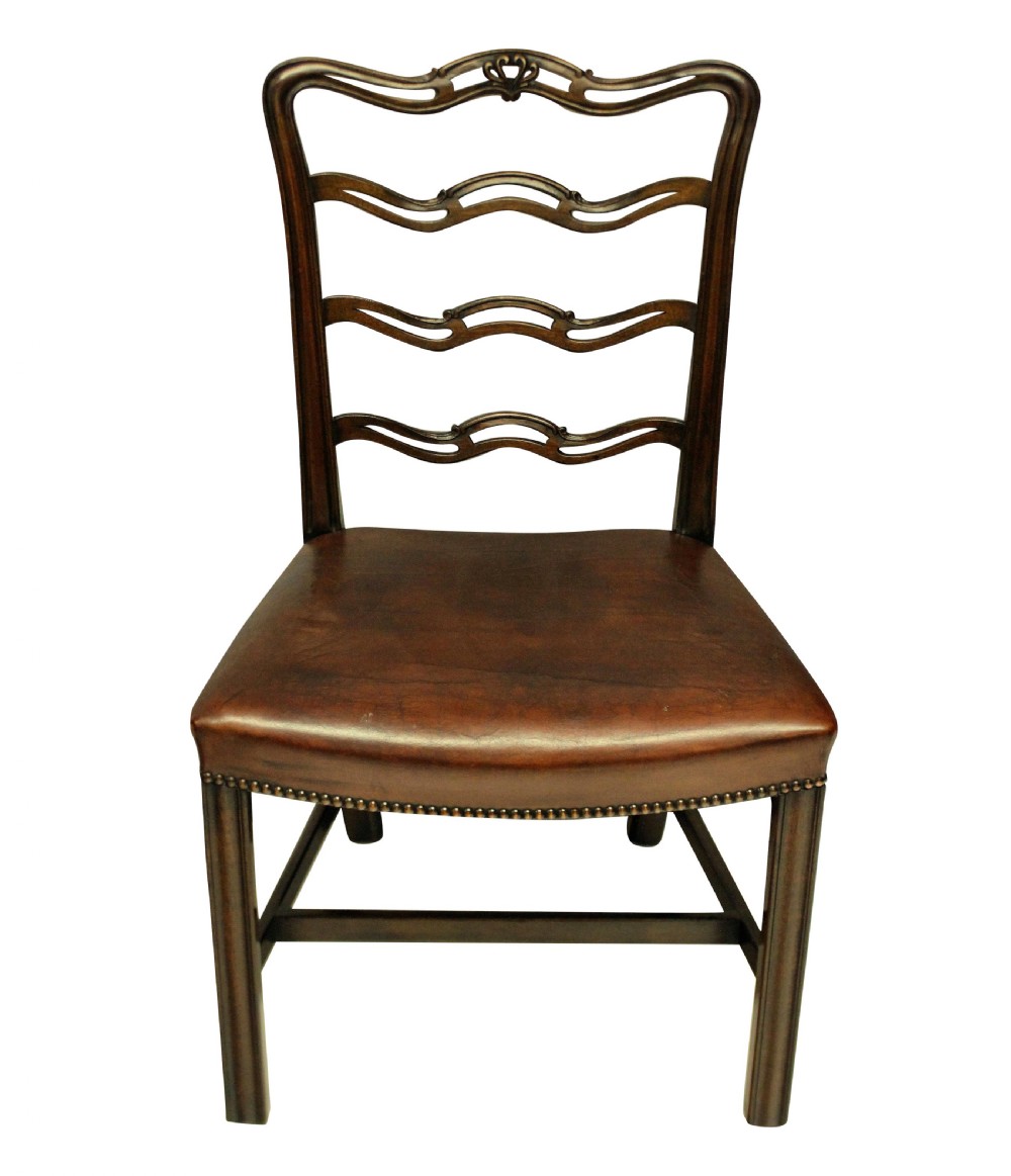 A set of six dark mahogany George III style ladderback dining chairs with brass-studded brown leather seats. View II