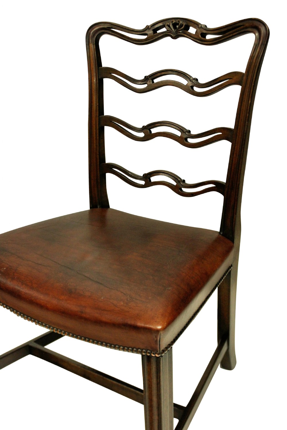 A set of six dark mahogany George III style ladderback dining chairs with brass-studded brown leather seats. View III