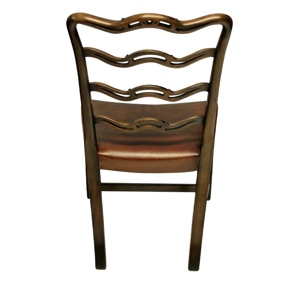 A set of six dark mahogany George III style ladderback dining chairs with brass-studded brown leather seats. View IV