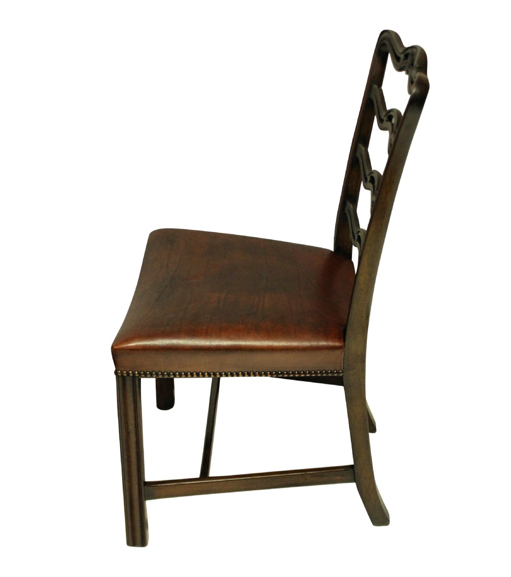 A set of six dark mahogany George III style ladderback dining chairs with brass-studded brown leather seats. View V